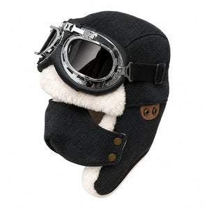 Black men's winter aviator hat with goggles, faux fur lining, ear flaps, and warm outdoor style on a clean white background.