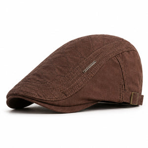 Brown men's adjustable quilted flat cap with classic ivy silhouette and clean white background.