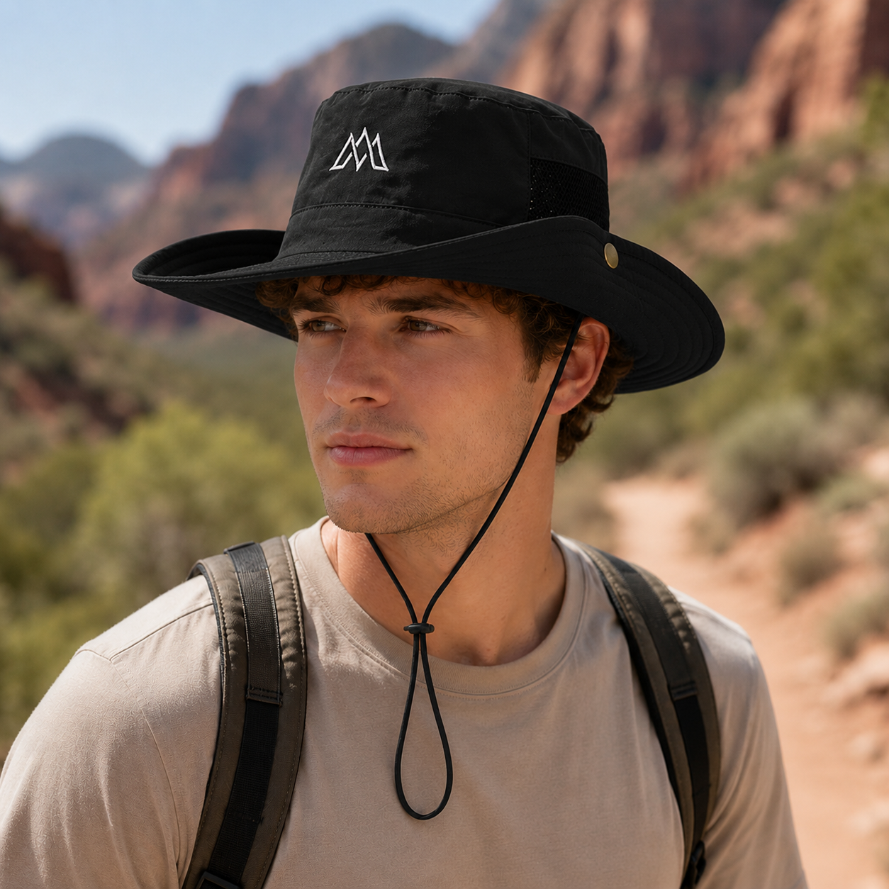Black outdoor sun protection bucket hat with adjustable chin cord, breathable mesh panel, snap-up side brim, and casual outdoor style