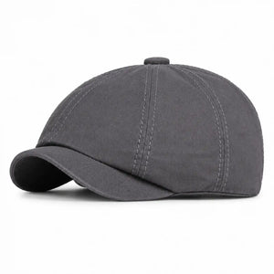 Dark gray vintage newsboy cap with curved brim and elastic back fit