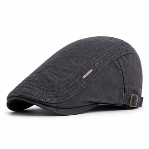 Gray men's adjustable quilted flat cap with classic ivy cap shape and clean white background.