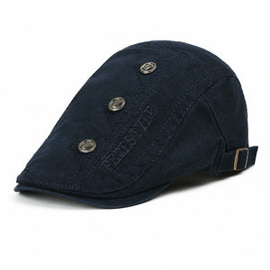 Navy vintage flat cap for men with adjustable back buckle, decorative metal button details, and cotton fabric on a clean white background.