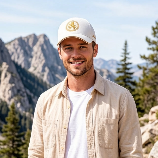 White embroidered cotton baseball cap with gold front emblem, curved brim, and adjustable unisex fit